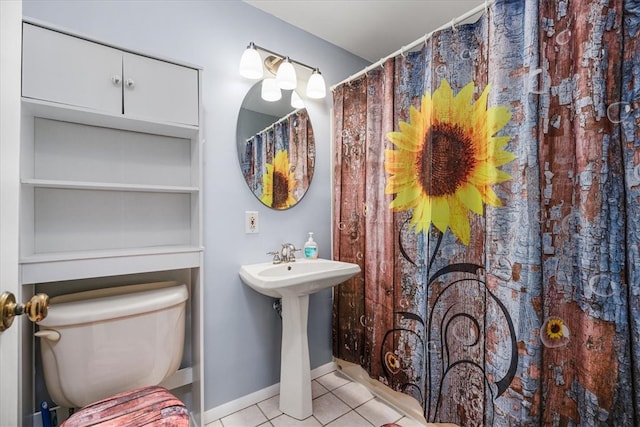 bathroom featuring toilet, walk in shower, sink, and tile patterned floors