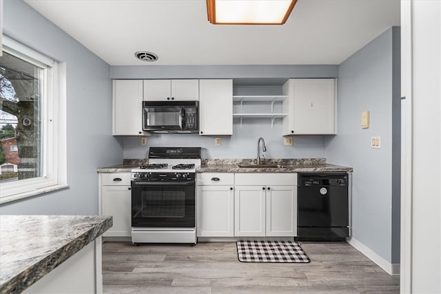 kitchen with white cabinetry, light hardwood / wood-style floors, black appliances, and sink