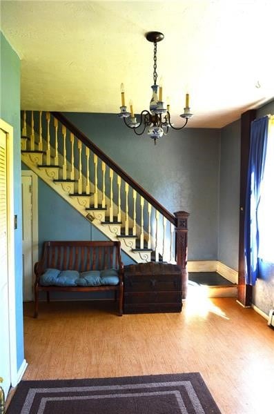 stairs featuring hardwood / wood-style flooring and a notable chandelier