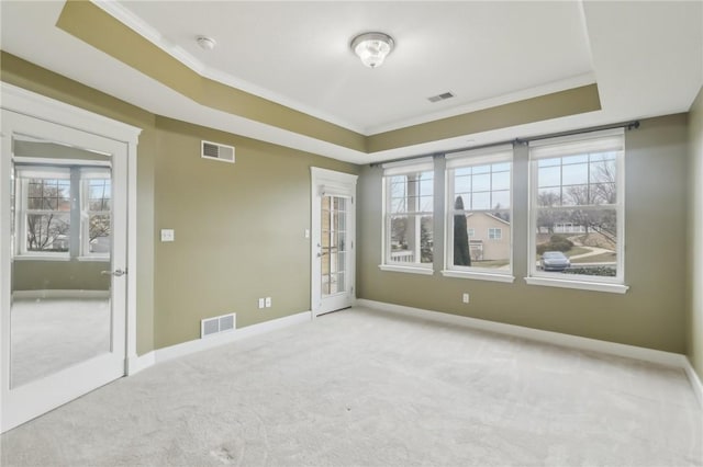 spare room with visible vents, a raised ceiling, and ornamental molding