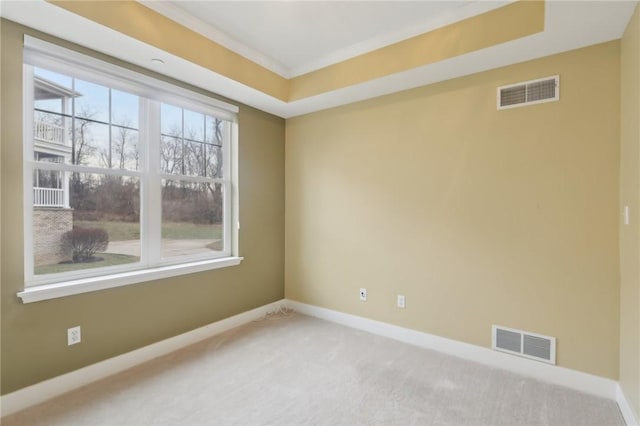 carpeted empty room with crown molding, visible vents, and baseboards