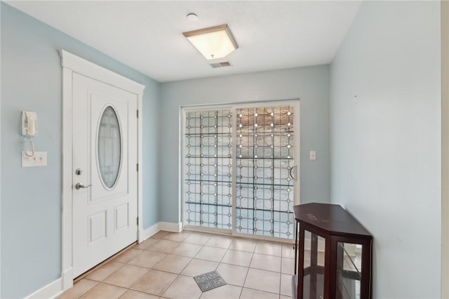 foyer featuring baseboards, visible vents, and light tile patterned flooring