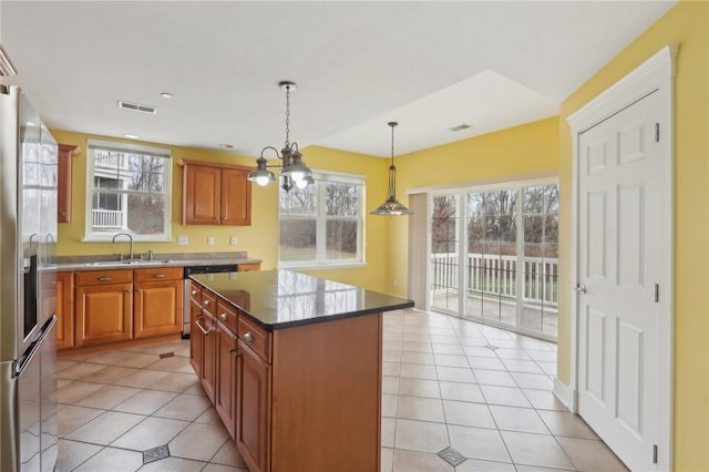 kitchen featuring stainless steel appliances, visible vents, hanging light fixtures, light tile patterned flooring, and a sink