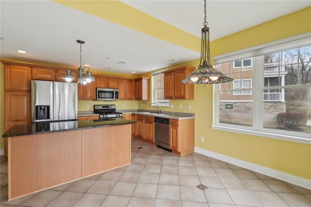 kitchen featuring stainless steel appliances, recessed lighting, hanging light fixtures, a sink, and baseboards