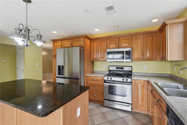 kitchen featuring light tile patterned flooring, recessed lighting, a kitchen island, a sink, and appliances with stainless steel finishes