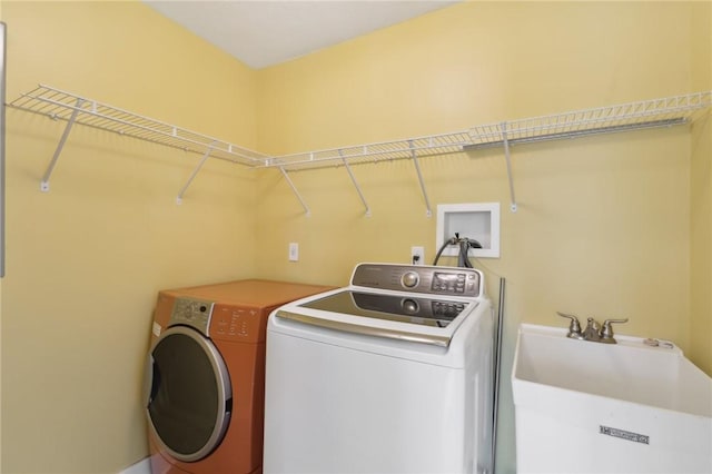 washroom with laundry area, a sink, and separate washer and dryer