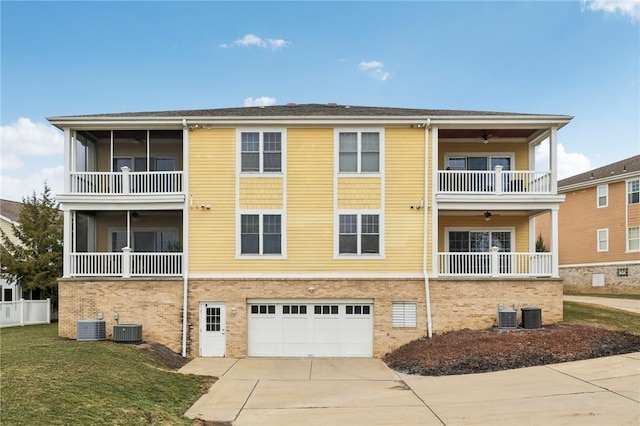 view of property featuring driveway, an attached garage, and central air condition unit