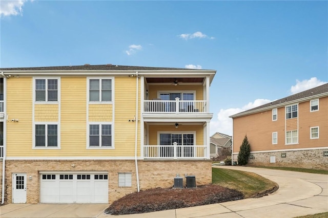 view of front of home featuring central AC, a ceiling fan, concrete driveway, and brick siding