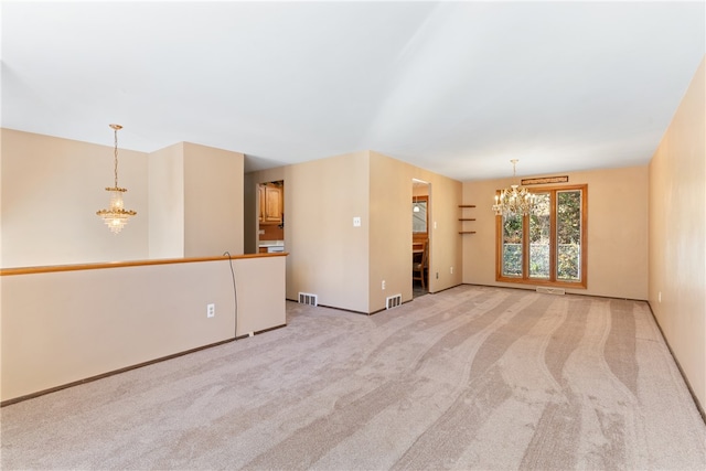 unfurnished room with light carpet and an inviting chandelier