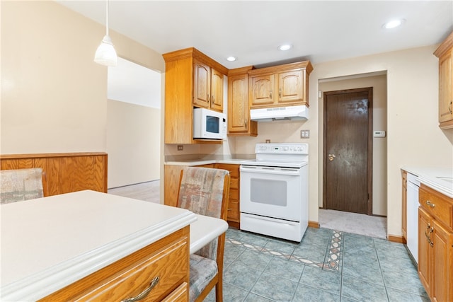 kitchen featuring white appliances, decorative light fixtures, and light tile patterned flooring