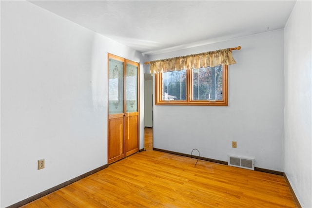 empty room with light hardwood / wood-style flooring