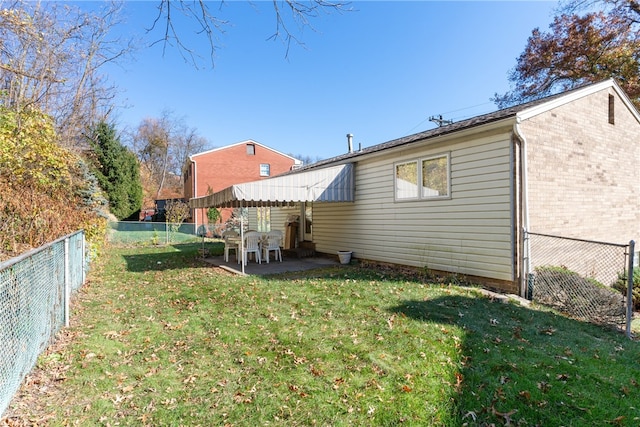 rear view of house with a yard and a patio area