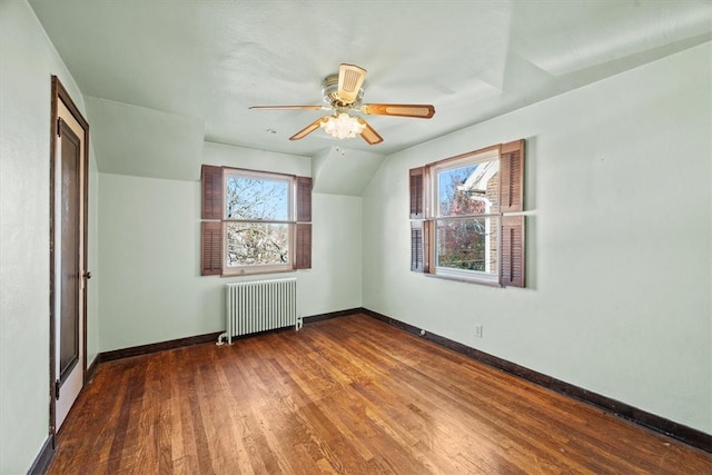 additional living space featuring radiator heating unit, hardwood / wood-style floors, vaulted ceiling, and ceiling fan