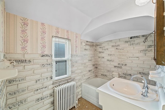 bathroom featuring a tub to relax in, radiator heating unit, vaulted ceiling, and brick wall