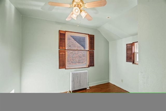 additional living space featuring hardwood / wood-style flooring, ceiling fan, vaulted ceiling, and radiator