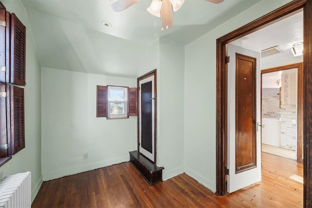 interior space with dark wood-type flooring, radiator, lofted ceiling, and ceiling fan