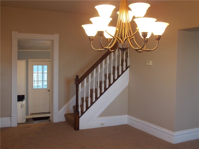 carpeted entrance foyer with a notable chandelier