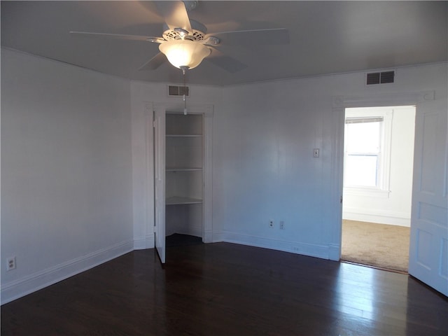 spare room featuring ceiling fan and dark wood-type flooring