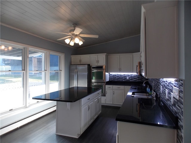 kitchen with white cabinetry, a center island, sink, stainless steel appliances, and dark hardwood / wood-style flooring