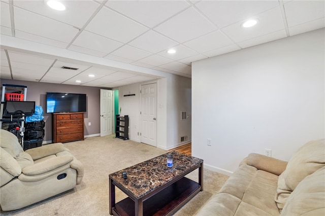 carpeted living room with a drop ceiling