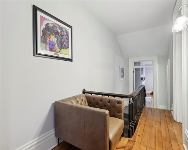 hall with light hardwood / wood-style floors and lofted ceiling