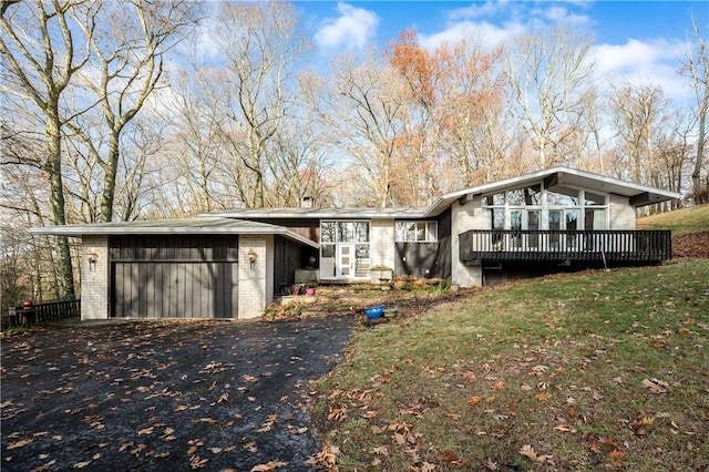 exterior space featuring a garage, a deck, and a front yard