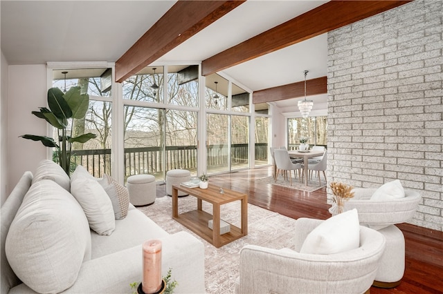 sunroom with vaulted ceiling with beams and an inviting chandelier