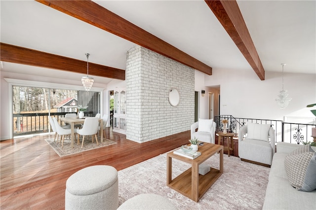 living room featuring vaulted ceiling with beams, light hardwood / wood-style flooring, and a notable chandelier