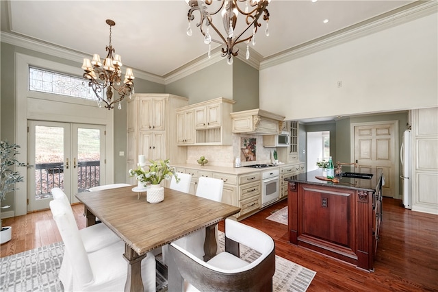 kitchen featuring decorative backsplash, french doors, refrigerator, pendant lighting, and cream cabinets