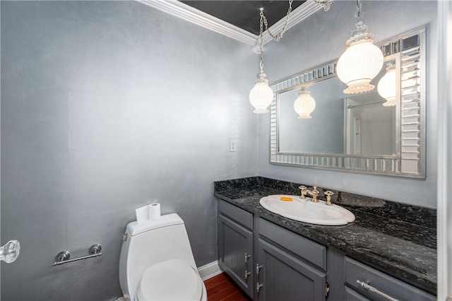 bathroom with wood-type flooring, vanity, toilet, and ornamental molding