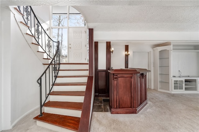 stairway with carpet flooring and a textured ceiling