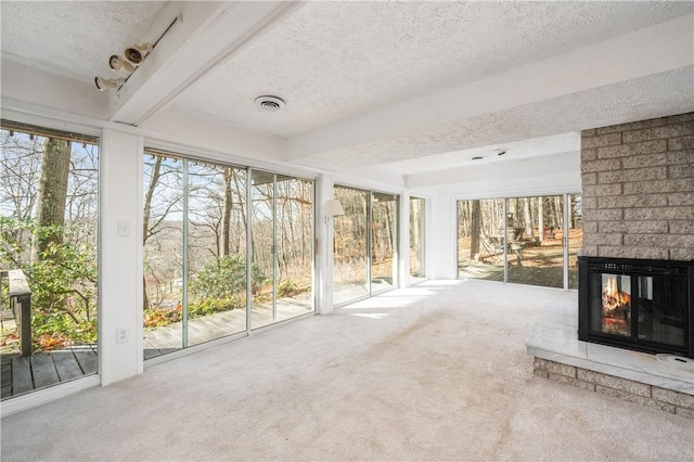 unfurnished sunroom featuring plenty of natural light and a brick fireplace