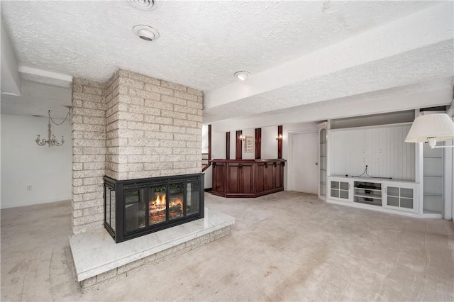 unfurnished living room featuring a fireplace, carpet floors, and a textured ceiling