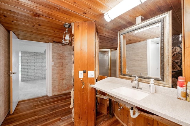 bathroom featuring hardwood / wood-style flooring, wooden ceiling, and sink