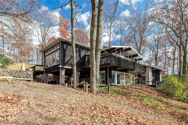 back of property featuring a wooden deck and a sunroom