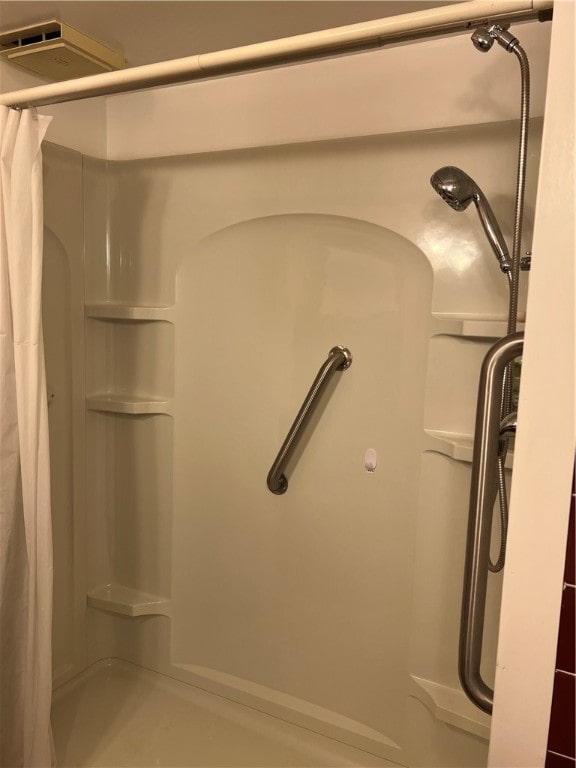 interior details featuring a shower with shower curtain