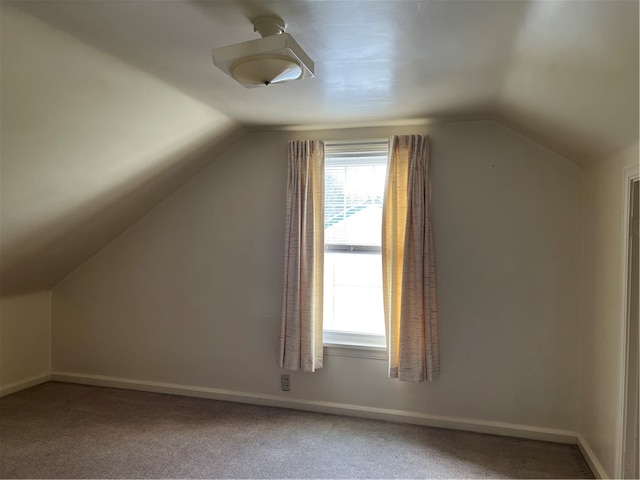 additional living space with carpet floors and vaulted ceiling