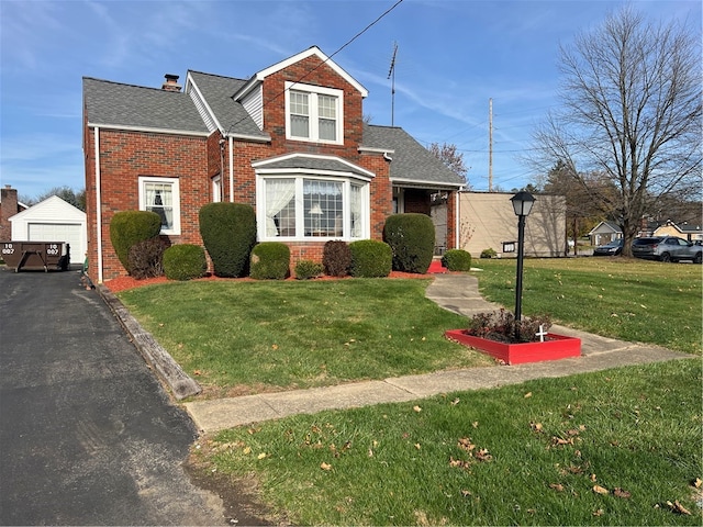 view of front of property featuring a front lawn, an outdoor structure, and a garage