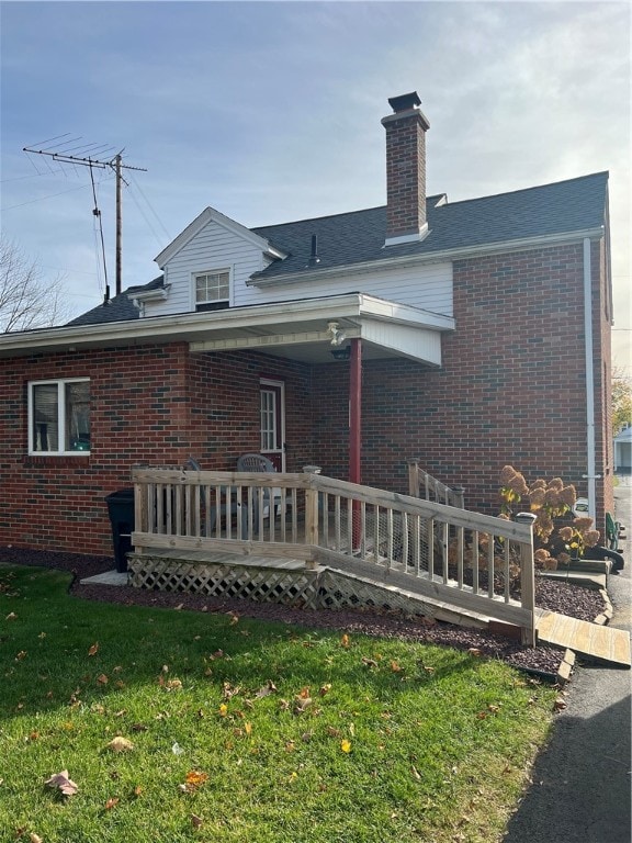 rear view of property with a lawn and a wooden deck