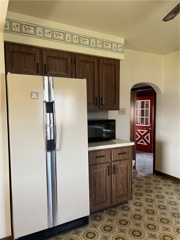 kitchen with ceiling fan, dark brown cabinets, and white refrigerator