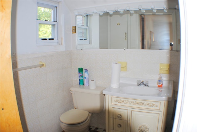 bathroom featuring vanity, toilet, and tile walls