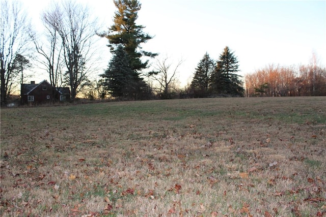 yard at dusk featuring a rural view