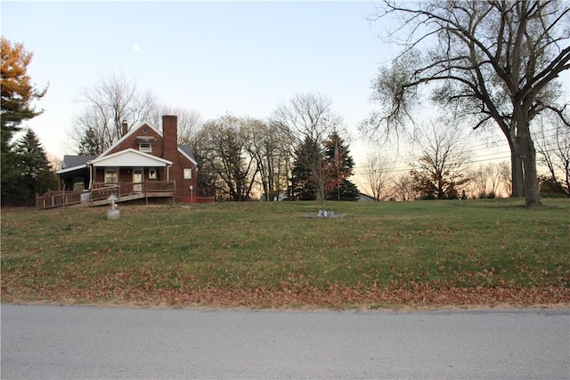 yard at dusk featuring covered porch