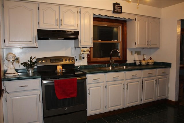 kitchen featuring electric range, dark tile patterned floors, white cabinetry, and sink