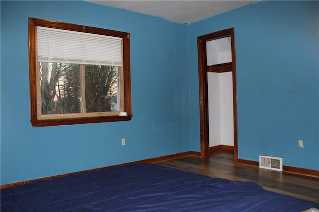 unfurnished bedroom featuring dark hardwood / wood-style flooring