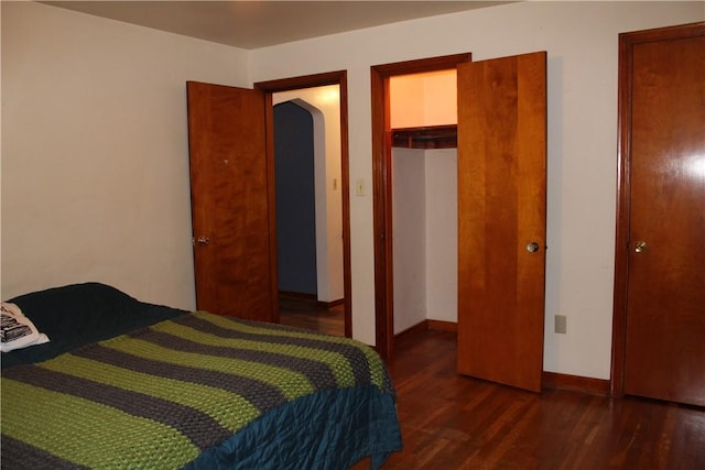 bedroom with dark hardwood / wood-style floors and a closet