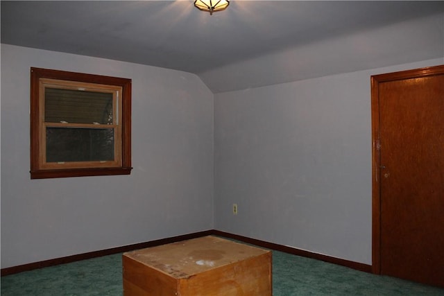 additional living space with vaulted ceiling and dark colored carpet