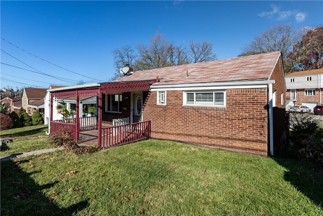 back of house featuring covered porch and a lawn