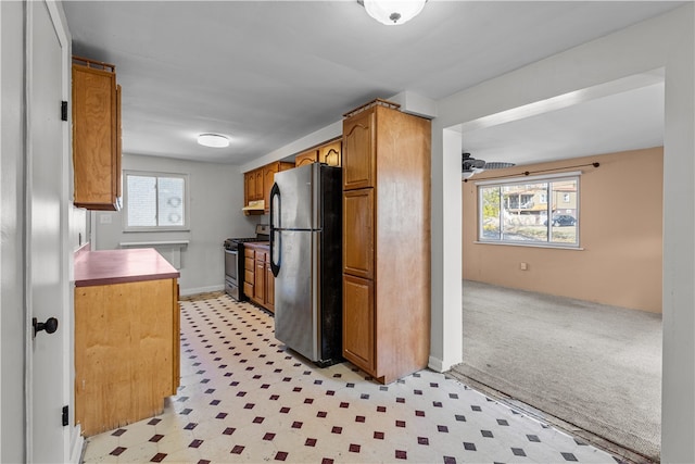 kitchen with stainless steel appliances and light colored carpet