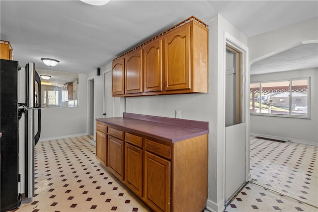 kitchen featuring stainless steel fridge and a healthy amount of sunlight